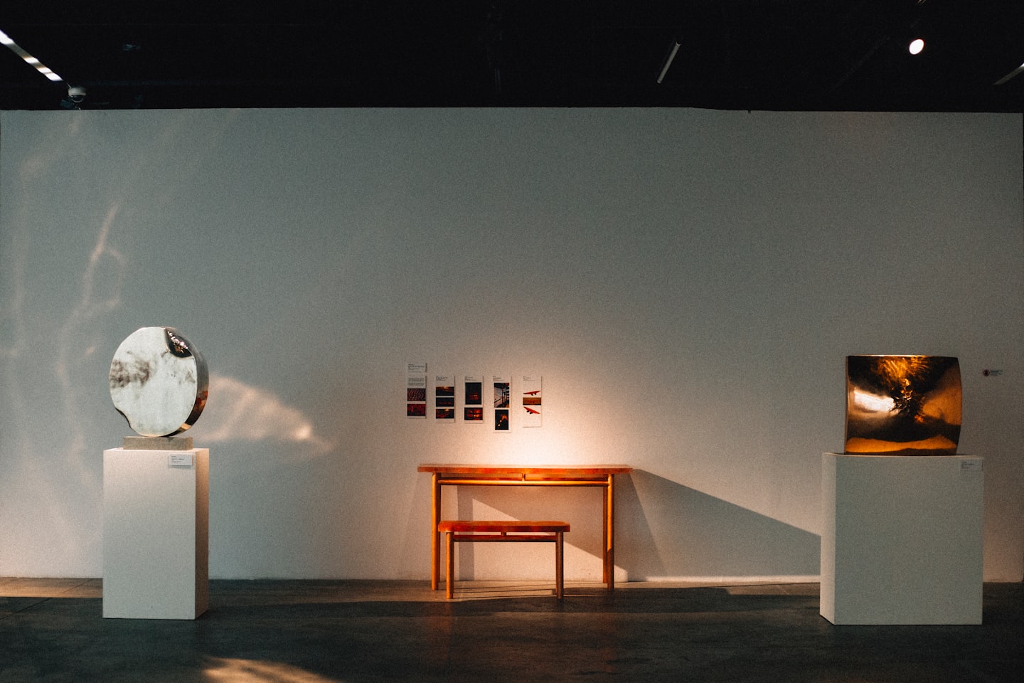 Dos esculturas abstractas en una galería de arte minimalista.